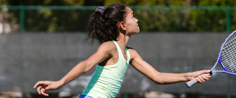 adolescent girl playing tennis