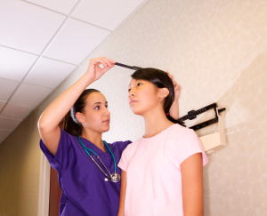 nurse measuring an adolescent girl's height